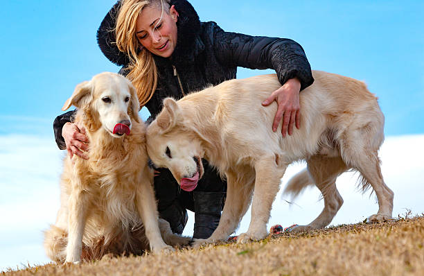 Young woman and her pets having a funny time in outdoor