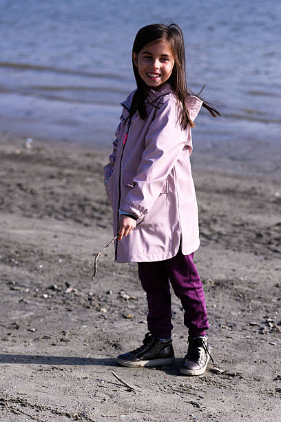 istock Little girl playing on sandy beach smiling 2247352265