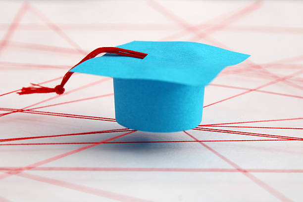 Graduation cap on blue background, university degree celebration, academic achievement ceremony