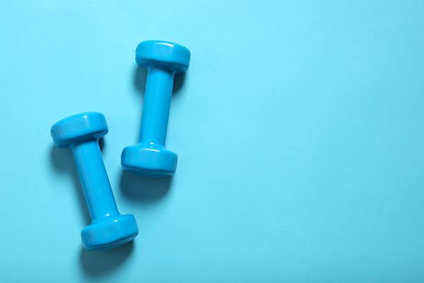 istock Pair of blue dumbbells, isolated on color background 2247353738