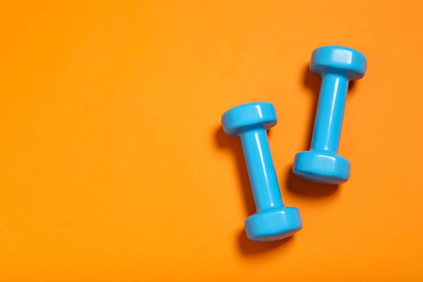 istock Modern dumbbells on a color floor 2247353826