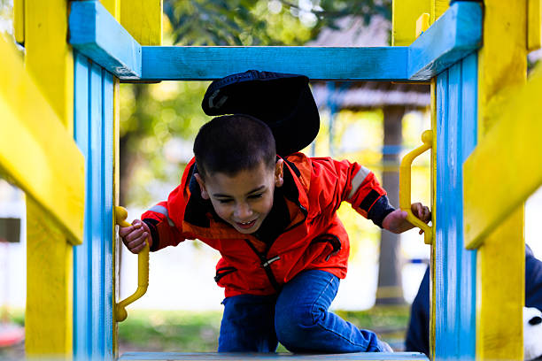 istock Child climbing colorful playground structure, having fun outdoors 2247354579