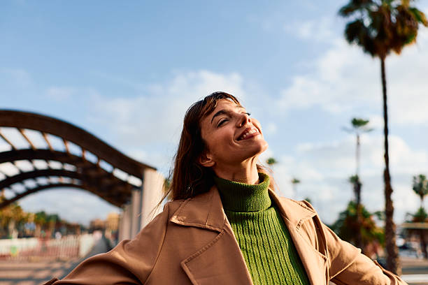 istock Woman smiling enjoying sunshine with arms open 2247356150