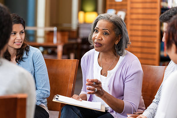 istock A mental health professional leads a group therapy session discussing important life issues. 2247357368