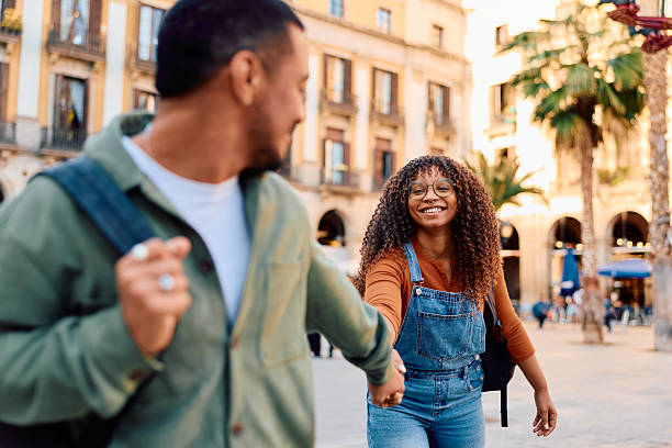 istock Happy couple holding hands exploring city street 2247357640
