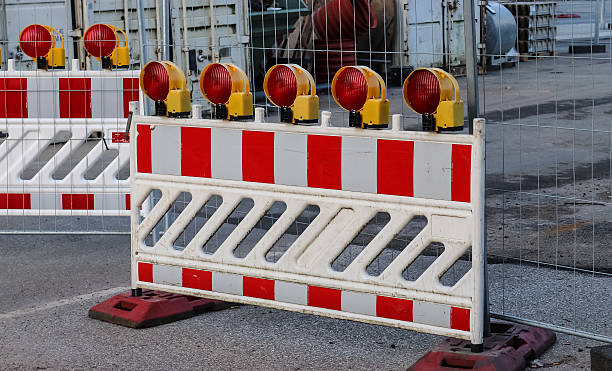 istock Road construction barriers with flashing warning lights 2247359463