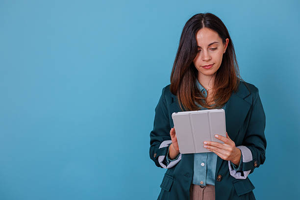 istock Woman standing and focusing on her digital tablet, working, browsing, and connecting online for business 2247364723