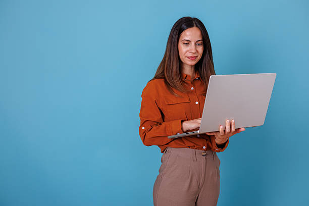 istock Woman standing and working remotely on a laptop, using technology for communication and online business 2247364815