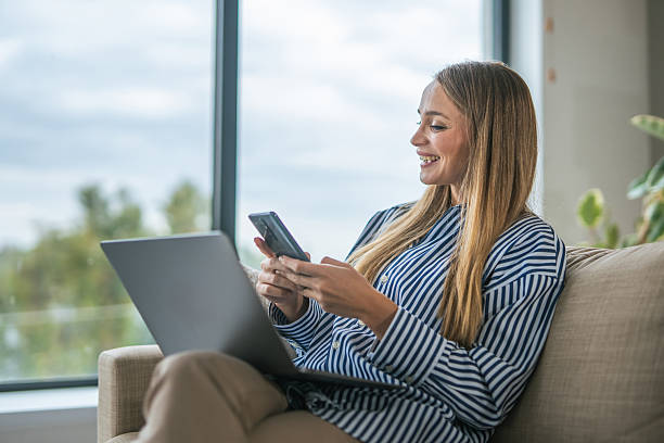 istock Woman working remotely at home using laptop phone 2247366802