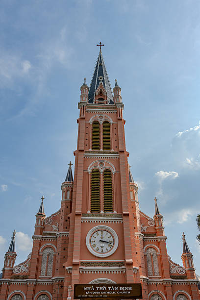Frontal view of the iconic pink Tan Dinh Church in Ho Chi Minh City, Vietnam, photographed under a bright blue sky. The vibrant façade, ornate architecture and pastel colors create a striking contrast, highlighting one of the city’s most famous landmarks. Perfect for travel, architecture and cultural themes.