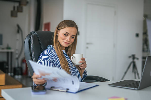 istock Woman working from home reviewing documents drinking coffee 2247367065