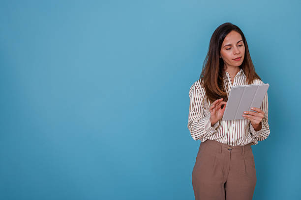 istock Confident businesswoman holding tablet, working on project or browsing internet. Demonstrating technology, connectivity, and remote work 2247367120