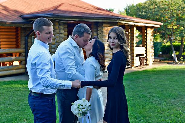 Happy, portrait and family at a wedding to support happiness, love and the marriage together. Old man, sister and brothers of the groom with mother holding a bouquet of flowers at an event outdoors