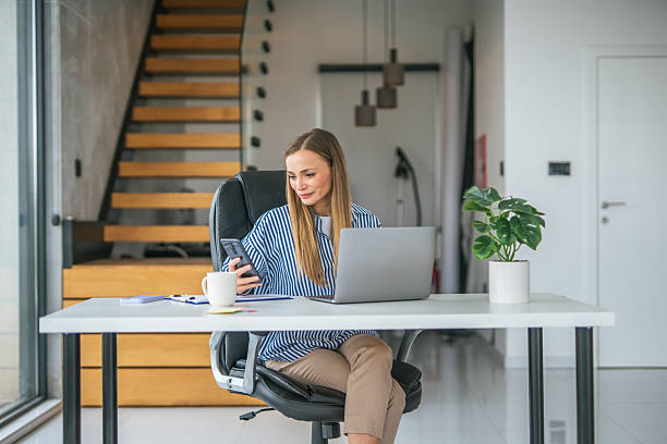 istock Woman working from home office using laptop and phone 2247367321