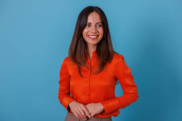 istock Professional woman smiling, looking away on a blue background, expressing happiness and optimism 2247367644