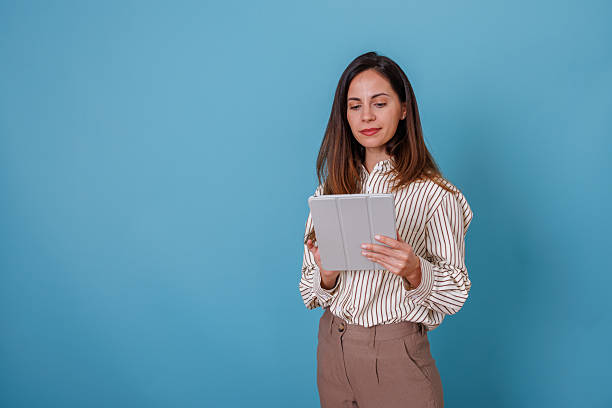 istock Professional woman using digital tablet for business and remote working on blue background 2247367841