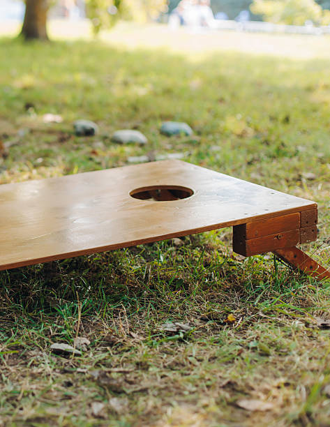 istock Cornhole game set, process of throwing bean bags, kids children with parents tossing bean sacks, backyard lawn corn hole , wooden boards for corn-hole tournament in the summer sunny day in a city park 2247367911