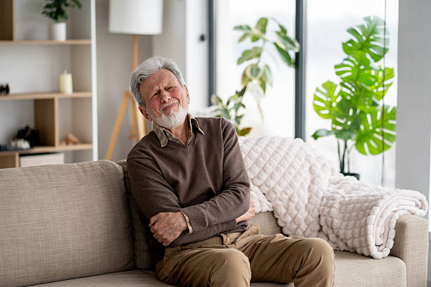 istock Senior Man in Pain on a Couch with a Pained Expression 2247370473