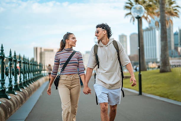istock Excited Hispanic Couple Strolling Along Sydney's Scenic Waterfront 2247371159