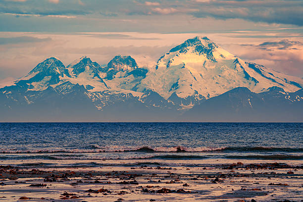 istock Snowy mountains meet the sea at sunset. 2247375759