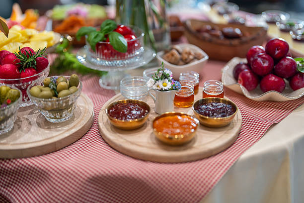A diverse array of breakfast items arranged on a checkered tablecloth at a vintage boutique hotel's self-service bar.
