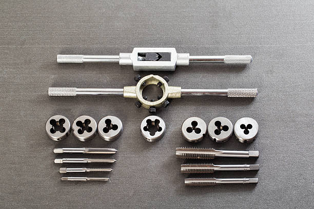 istock Precision metalworking tap and die set including tap wrenches and various thread cutting tools displayed on dark gray surface for mechanical engineering and repair projects 2247376166
