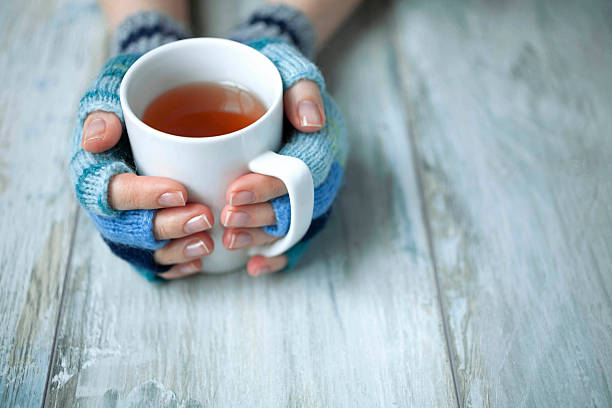 istock Hands in fingerless gloves holding warm drink 2247376657