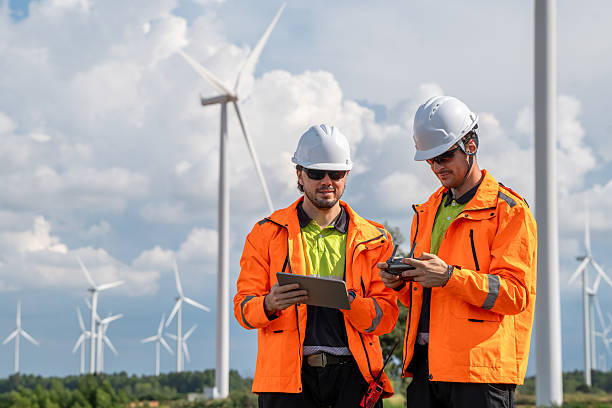 istock Engineers using drone and tablet for wind turbine inspection at wind farm. Two engineers (two men) operating a drone for inspecting wind turbines, concept of technology and sustainability. 2247377677