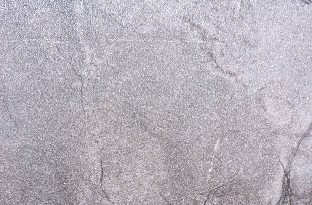 Gray marble, a polished surface of natural light-colored stone with black veins. Background, texture.