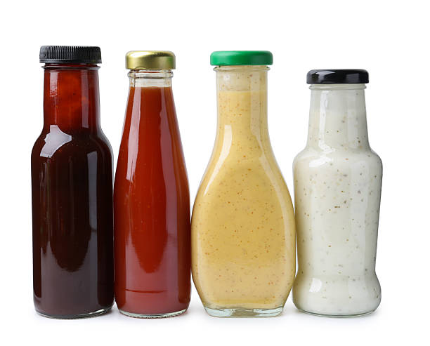 istock Different delicious sauces in glass bottles isolated on white 2247380820