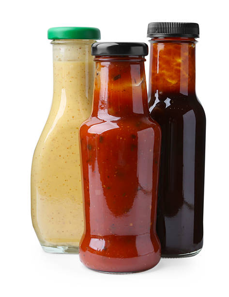 istock Different delicious sauces in glass bottles isolated on white 2247380823