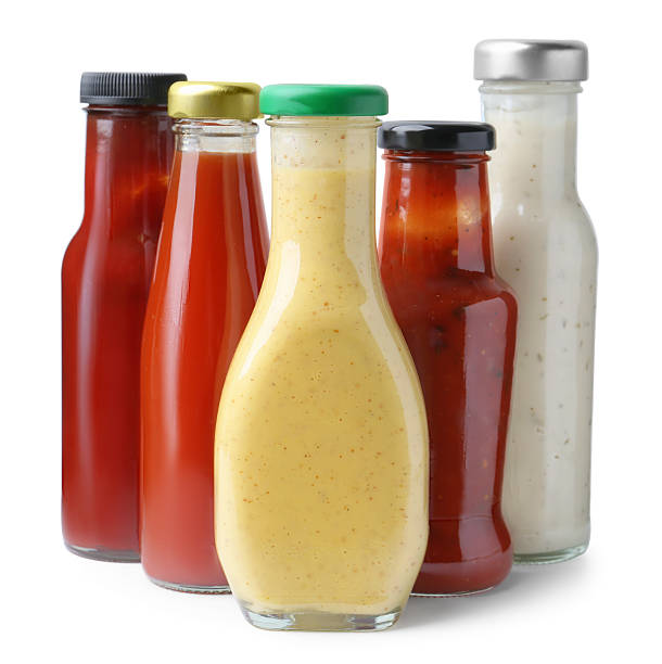 istock Different delicious sauces in glass bottles isolated on white 2247380825