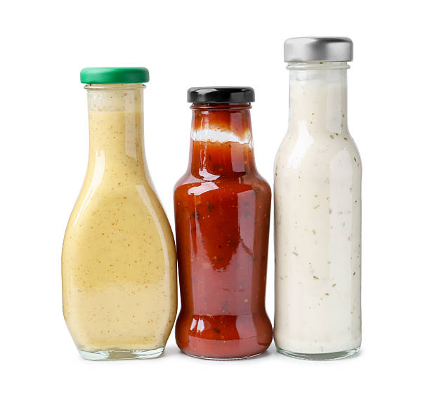 istock Different delicious sauces in glass bottles isolated on white 2247380833