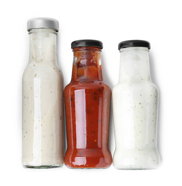 istock Different delicious sauces in glass bottles isolated on white, top view 2247380885