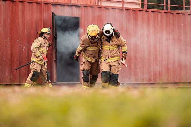 istock A team of firefighters evacuates an injured colleague from a smoke-filled training structure 2247381096