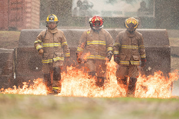 istock A group of firefighters in full protective gear walks through ground flames 2247381454