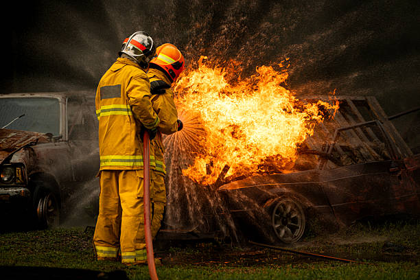 istock Two firefighters standing in position while directing a powerful water stream at a large blaze 2247381536