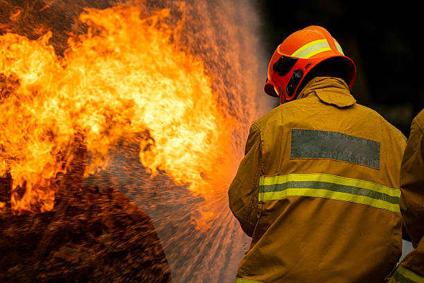 istock firefighters kneel in position while directing a powerful water stream at a large blaze 2247381559