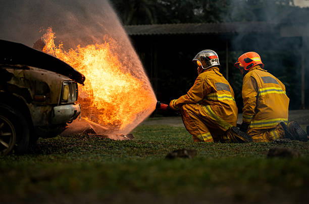 istock Two firefighters kneel in position while directing a powerful water stream at a large blaze 2247381584