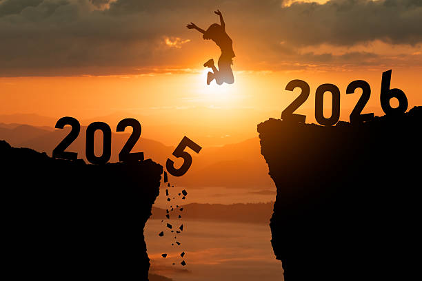 istock Person jumps over a gap between two cliffs representing year transition from 2025 to 2026, capturing a moment of hope and adventure at sunset 2247384985