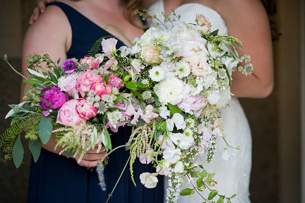 istock Bride and Bridesmaid Holding Vibrant and Soft Floral Bouquets 2247387098