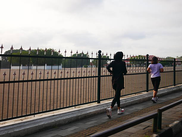 Athletic man taking refreshment from volunteers on a marathon race at sunset.