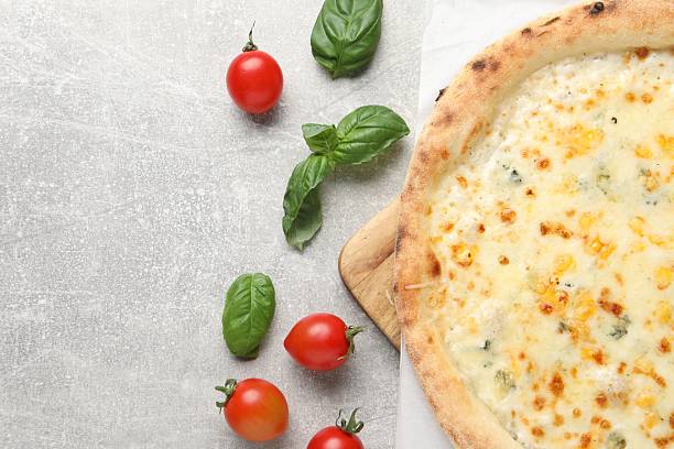 istock Delicious cheese pizza, basil and tomatoes on light grey table, flat lay. Space for text 2247390855