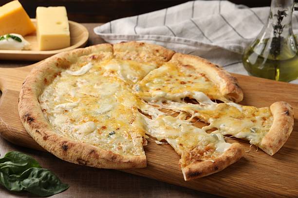 istock Delicious cut cheese pizza and ingredients on wooden table 2247390932