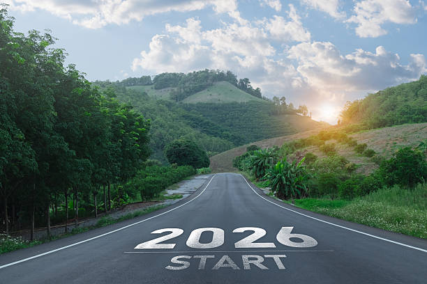 istock A Scenic Open Road Leading Towards a Bright Future with 2026 Start Marked on the Asphalt Surrounded by Lush Green Hills and a Cloudy Sky 2247392481