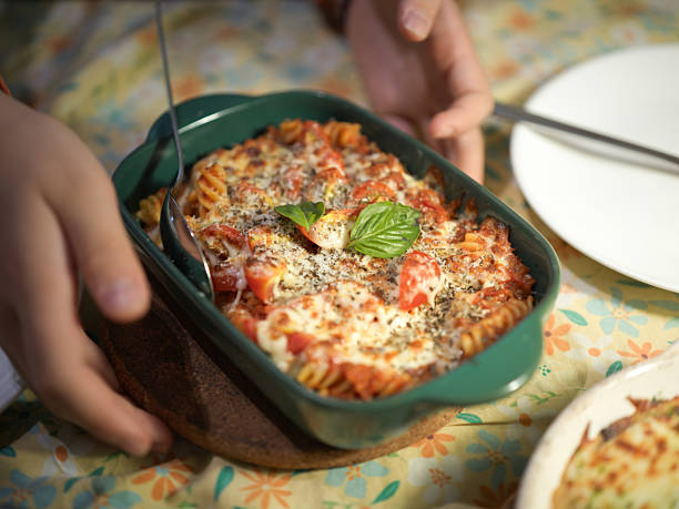 istock Baked Pasta with Tomatoes and Basil in a Green Casserole Dish Served at a Dinner Table 2247397840