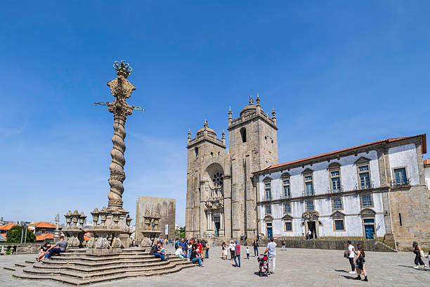 Tourists strolling in front of the imposing Porto Cathedral, dating back to the 12th century, with a baroque style that was given to it in the 17th and 18th centuries: the portal still conserves the medieval rose window.
