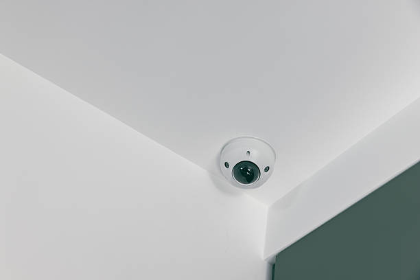 istock IP CCTV camera on white background with home security system concept. CCTV camera on the ceiling 2247411819