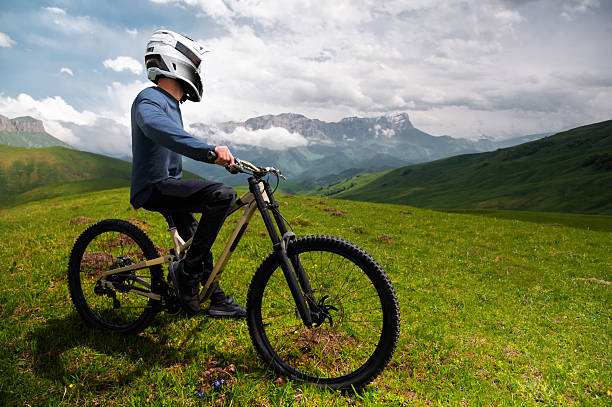 istock Unrecognizable man with bicycle. Mountain biker stands after riding through summer mountain forest landscape. Outdoor sports 2247411831