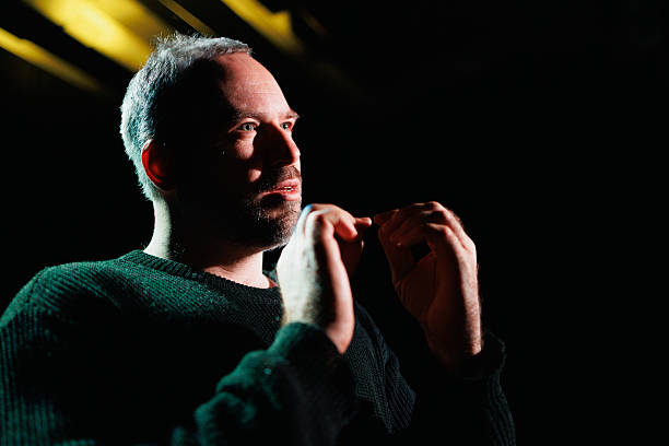 istock Actor in theater rehearsing on black background 2247411972